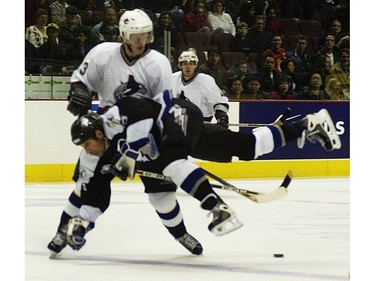 Dec.  10, 2001: Henrik Sedin (#33) upends Tampa Bay Lightning forward Dave Andreychuk (#25) during first period NHL action at GM Place.