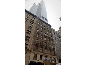 The residential skyscraper One57, a gleaming 75-story glass high-rise on West 57th, sits behind the once low-budget Park Savoy Hotel, center, in a Manhattan neighborhood of sprouting luxury towers dubbed "Billionaires' Row," Wednesday April 4, 2018, in New York. A city plan to build a homeless shelter in the defunct hotel has sparked a real-estate turf war, with opponents fearing a threat to property values.