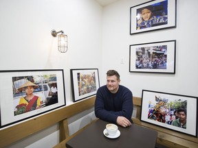 Avid photographer and lawyer Marco Francesco prepares to hang his photos from Cambodia and Myanmar at The Drive Coffee Bar. Profits from the sale of the photos will go to support Rohingya refugees.