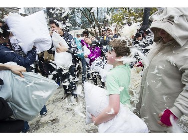 Liam Broomfeld, age 10 prepares to throw a handful of feathers from a burst pillow at pillow fight on the Robson street plaza side of the Vancouver art Gallery to celebrate International Pillow Fight Day, Vancouver, April 07 2018.