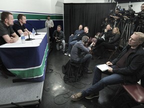 Daniel, left, and Henrik Sedin speak with reporters Monday in Vancouver after announcing their retirement after 17 NHL seasons with the Canucks.