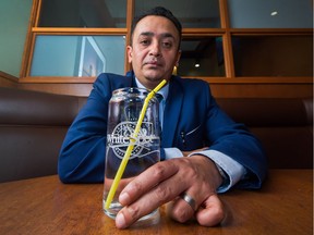 White Spot general manager Naseer Khwaja with a straw inside the restaurant in Vancouver on April 2. Vancouver-area restaurants and bars have stopped providing plastic straws with their drinks. White Spot will give straws only to customers who ask.