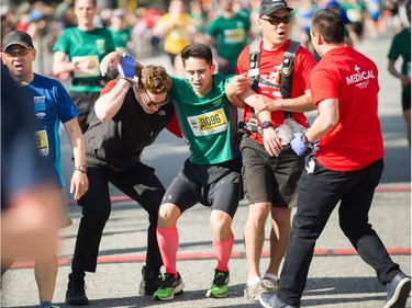 Joshua Juni of Burnaby, who finished 57th,  is helped at the finish line in the Vancouver Sun Run in Vancouver, BC, April 22, 2018.