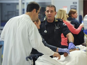 BC Ambulance paramedics confer with Emergency Department doctor Frank Scheuermeyer (left) about an intoxicated man brought to the hospital moments earlier.