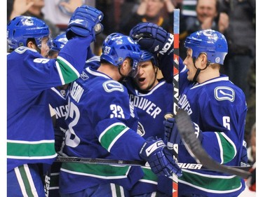 February 3, 2009: Vancouver Canucks Kevin Bieksa (3, center) celebrates his goal against the  Carolina Hurricanes with teammates Henrik Sedin (33) and Sami Salo (6) during first period NHL regular season action at GM Place.