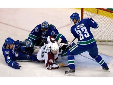 Feb. 9, 2008: Vancouver Canucks' goalie Roberto Luong (1) defends alongside defenceman Mike Weaver (18) and centre Henrik Sedin (33) as  Colorado Avalanche centre Ben Guite (28) goes down in front of the net  during first period