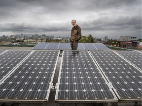 Rob Baxter with solar panels on the roof of Vancouver Renewable Energy in Vancouver, BC. April 12, 2016.