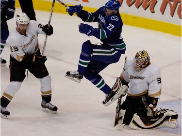 Nov. 27, 2007: Daniel jumps to avoid a point shot in front of Anaheim Ducks goalie Jean-Sebastien Giguere (35) as he's checked by Francois Beauchemin (23) during the second period.