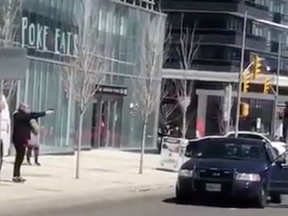 A screenshot of a video posted to social media shows the suspect pointing an object at a police officer.