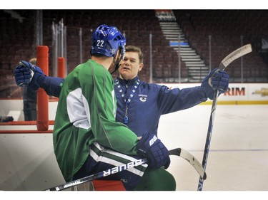 March 12, 2010: Canucks assistant coach Ryan Walter(R) expounds to forward  Daniel Sedin(L) at the bench during  the team practice Friday.