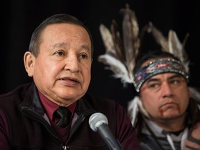 Grand Chief Stewart Phillip, left, President of the Union of B.C. Indian Chiefs, speaks as William George, a member of the Tsleil-Waututh First Nation and a guardian at the watch house near Kinder Morgan's Burnaby facility, listens during a news conference with Indigenous leaders and politicians opposed to the expansion of the Trans Mountain pipeline, in Vancouver, B.C., on Monday April 16, 2018.