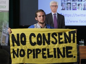 Trans Mountain Pipeline protester Gabriel D'astous interrupts a speech by Natural Resources Minister Jim Carr at the "Positive Energy" conference at the University of Ottawa on Monday, April 23, 2018.
