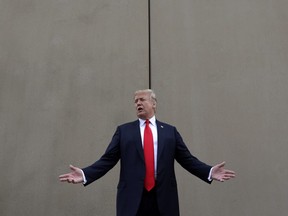 In this March 13, 2018 photo, President Donald Trump speaks during a tour as he reviews border wall prototypes in San Diego.