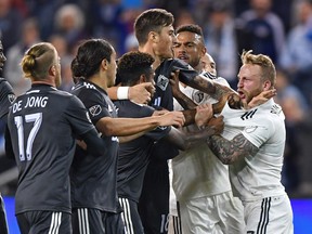 Sporting KC forward Johnny Russell, right, reacts after getting shoved to the ground by Vancouver Whitecaps forward Yordi Reyna during the first half of Friday's MLS game at Children's Mercy Park. The Whitecaps dropped their third straight game with a 6-0 loss.