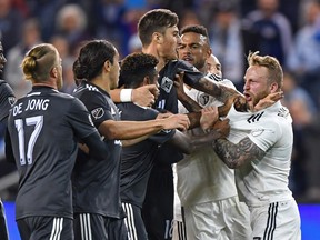 Sporting Kansas City forward Johnny Russell, right, reacts after getting shoved by Vancouver Whitecaps forward Yordi Reyna during MLS action at Children's Mercy Park last week.