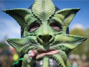 A man wears a marijuana-leaf mask during the annual 4/20 cannabis-culture celebration at Sunset Beach in Vancouver on April 20, 2017.