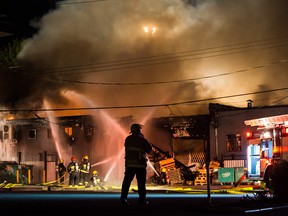 Firefighters battle a three-alarm fire at a commercial print shop in Vancouver, late Wednesday April 25, 2018.