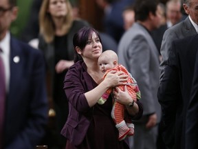 NDP Member of Parliament Christine Moore carries her daughter Daphnee after casting her ballot for a new Speaker in the House of Commons on Parliament Hill in Ottawa, Canada December 3, 2015.
