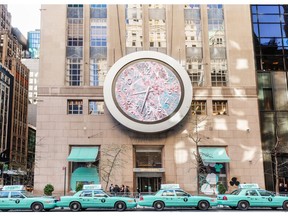 Interactive Atlas clock above the Fifth Avenue New York flagship store with Tiffany Blue taxis.