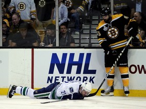 Mason Raymond #21 of the Vancouver Canucks lays on the ice after being checked by Johnny Boychuk #55 of the Boston Bruins during Game Six of the 2011 NHL Stanley Cup Final at TD Garden on June 13, 2011 in Boston, Massachusetts.