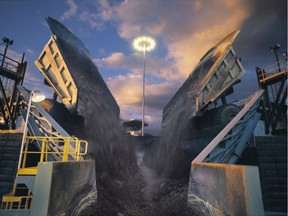 FILE PHOTO - The world's biggest dump trucks at the oil sands carry bitumen-rich sand to a crusher for transfer to processing facilities. Sand is then mixed with hot water and moved by pipeline.