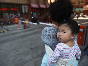 This photo taken on June 24, 2015 shows a woman carrying a baby in Yanji, in China's northeast Jilin province.