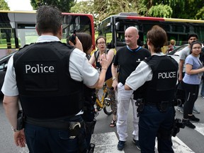Police officers speak with parents of children at a nearby high school in the eastern Belgian city of Liege on May 29, 2018, after a man killed three people including two policemen.
