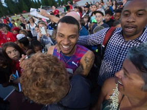 Canada's Andre De Grasse, centre, of Markham, Ont., is mobbed by children after racing to a first place finish in a time of 10.17 seconds during the 100-metre race at the Harry Jerome International Track Classic in Coquitlam, B.C., on Wednesday June 28, 2017.