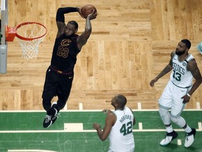 Cleveland Cavaliers forward LeBron James soars to dunk in front of Boston Celtics forward Al Horford (42) and forward Marcus Morris (13) during the first half in Game 7 of the NBA basketball Eastern Conference finals, Sunday, May 27, 2018, in Boston.