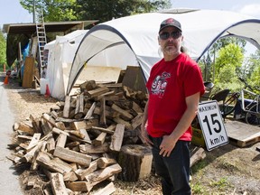 Black Wolf stands beside a pile of firewood donated to Camp Cloud on Burnaby Mountain, Burnaby  May 11 2018.