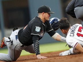 Atlanta Braves' Johan Camargo (17) is tagged out at second base by Miami Marlins shortstop Miguel Rojas, left,as he tries to stretch a single in the second inning of a baseball game Friday, May 18, 2018, in Atlanta.