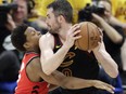 Raptors' Kyle Lowery tries to get the ball from Cavs' Kevin Love in Game 4. (AP PHOTO)