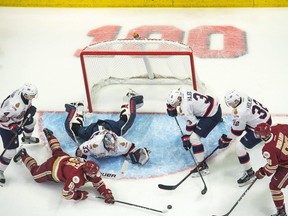 Players from the Regina Pats and Acadie-Bathurst Titan battle for a loose puck while Pats netminder Max Paddock lies helplessly on the ice during Sunday's Memorial Cup final at the Brandt Centre.