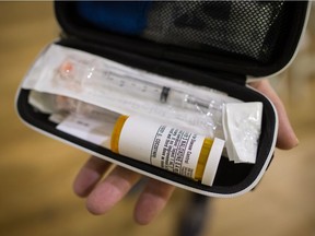 Deborah Buchanan displays the naloxone kit she received after learning how to respond to an overdose during a community meeting in Kitsilano, in Vancouver, B.C., on Monday November 13, 2017.