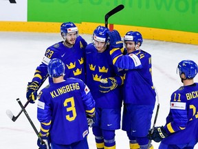 Sweden's Elias Pettersson (C) is congratulated by teamates after scoring a goal during the group A match Sweden vs France of the 2018 IIHF Ice Hockey World Championship at the Royal Arena in Copenhagen, Denmark, on May 7, 2018.