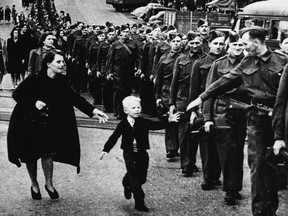 The photo 'Wait for me, Daddy' shows Private Jack Bernard, B.C. Regiment (Duke of Connaught's Own Rifles) saying goodbye to his son Warren (Whitey) Bernard, 5, as he leaves for the Second World War from New Westminster in  1940.