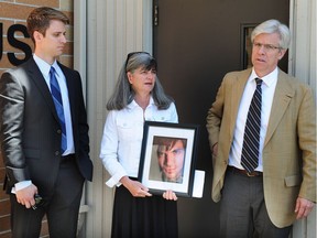 Lianne Dean, flanked by son Nathan and husband Tom, holds a photo Tuesday of her other son Bradley, a cyclist who was struck and killed in by a car driven by Michael Fan in November 2016.