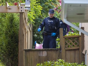 Police examine the scene on Thursday after a toddler died in a swimming pool next door to a daycare in Mission.