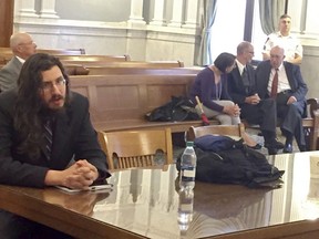Michael Rotondo, left, sits during an eviction proceeding in Syracuse, N.Y., brought by his parents, Mark and Christina, of Camillus. The two parents confer with their lawyer, Anthony Adorante, in the court gallery behind. Rotondo told the judge Tuesday, May 22, 2018, he knows his parents want him out of their Camillus home, near Syracuse. But he argued he's entitled to six months more time.