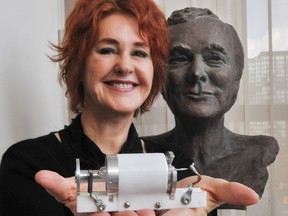 Kathleen Maiman holds the first laser ever created, made by her late husband Ted Maiman (that is a bust of Ted behind her), the couple moved to Vancouver in 1999.
