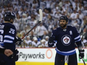 Winnipeg Jets defenceman Dustin Byfuglien and Blake Wheeler celebrate a power-play goal from Mark Scheifele (not shown) against the Vegas Golden Knights during Game 1 of their Western Conference final series in Winnipeg on Saturday.