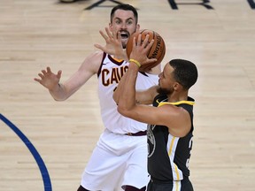Golden State Warriors guard Stephen Curry shoots a three-pointer over Cleveland Cavaliers forward Kevin Love in Game 2 on June 3.