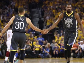 Golden State Warriors guard Stephen Curry (left) celebrates a basket with forward Kevin Durant in Game 2 against the Cleveland Cavaliers on June 3.