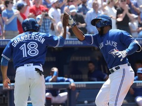 Teoscar Hernandez of the Toronto Blue Jays (right) is congratulated by Curtis Granderson after hitting a two-run home run in the fifth inning of their American League game at Toronto's Rogers Centre on Sunday.