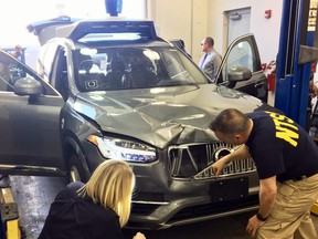 The National Transportation Safety Board, investigators examine a driverless Uber SUV that fatally struck a woman in Tempe, Ariz. on March 20, 2018. (National Transportation Safety Board via AP)