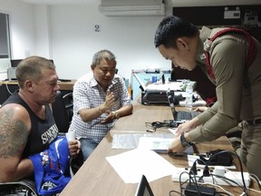 In this Monday, June 18, 2018, photo, Australian Stephen Allan Carpenter, left, is detained by police in Pattaya, Thailand.