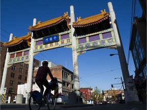 A cyclist rides along West Pender Street under the Chinatown gate in Vancouver on April 25.