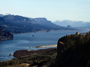 The Columbia River flows past the Vista House on Crown Point, right, with Beacon Rock visible in the distance near Corbett, Ore. Talks have begun to modernize the document that coordinates flood control and hydropower generation in the U.S. and Canada along the Columbia River.