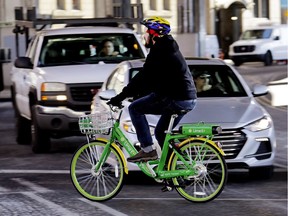 A man rides a shared electric-assisted bicycle in downtown Seattle. Shared bikes that can be left wherever the rider ends up are helping more people get access to the mode of transportation, but they are also producing some chaos with discarded bikes cluttering public spaces, blocking sidewalks and even placed in trees and lakes.