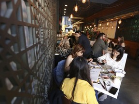 In this photo taken June 20, 2018, diners at the Tawla restaurant in the Mission District enjoy the Refugee Food Festival in San Francisco. San Francisco restaurants are opening their kitchens for the first time to refugees who are showcasing their culinary skills and native cuisines while raising their profiles as aspiring chefs as part of a program to increase awareness about the plight of refugees worldwide.